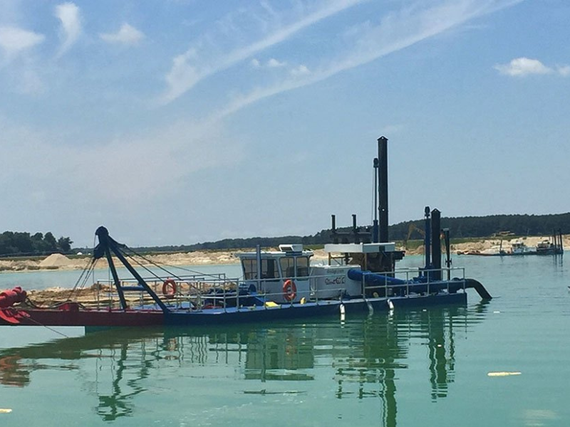 High volume sand dredging boat operating with high chrome sediment pumps for aggregate extraction.